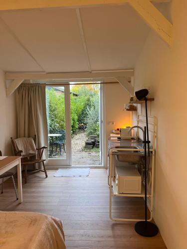 a bedroom with a bed and a table with a lamp at Cozy tiny house close to Schiphol Ams Airport in Rijsenhout
