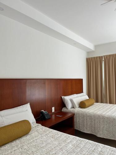 a hotel room with two beds and a telephone at Hotel Santiago in Jalpan de Serra