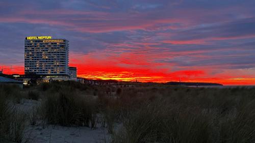 Ein hohes Gebäude vor dem Hintergrund eines Sonnenuntergangs in der Unterkunft Apartment Baltica in Rostock