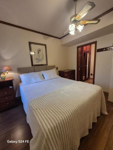 a bedroom with a large bed with a white bedspread at Apartment no Wish Serrano 53 in Gramado