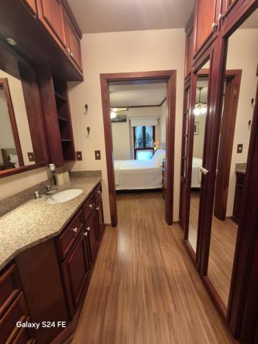 a bathroom with a sink and a bedroom at Apartment no Wish Serrano 53 in Gramado