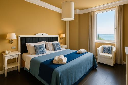 a bedroom with a bed with towels on it at Greif Hotel & Spa in Trieste