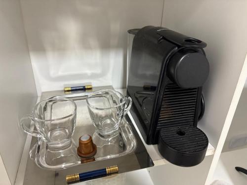 une cafetière avec deux tasses sur une étagère dans l'établissement Benjamin 190 Suites, à La Rioja