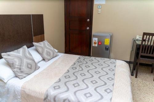 a bedroom with a large bed with white sheets and pillows at Urdesa Suites Hotel in Guayaquil