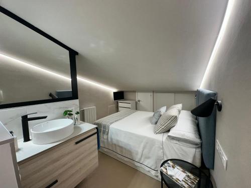 een slaapkamer met een bed, een wastafel en een spiegel bij Castillo 22 in Oropesa