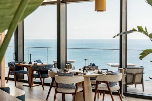 a restaurant with tables and chairs and a view of the ocean at Mercury tower Elena K 24th panoramic view apartment in St Julian's