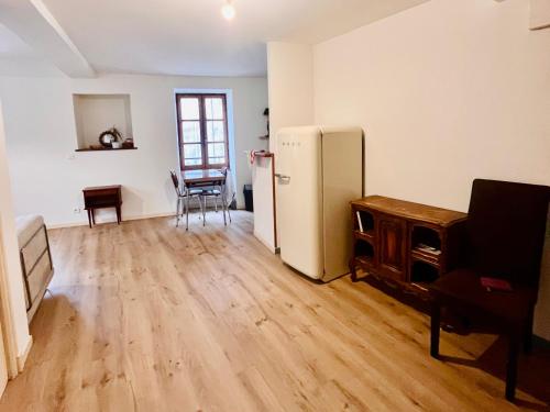 a living room with a refrigerator and a table at Appartement minimaliste et cozy in Cajarc