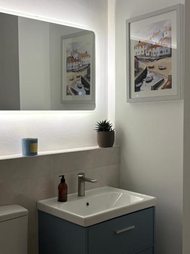 a bathroom with a sink and a mirror at Apt 1, Whiterocks Portrush in Portrush