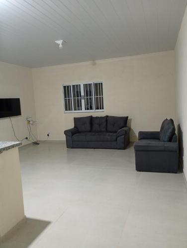 a living room with two couches and a television at Chácara Mirante das Colinas in Atibaia
