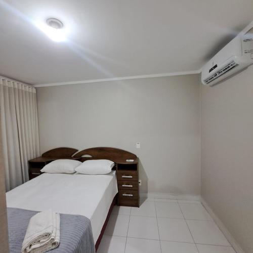 a bedroom with two beds and a dresser in it at Metropolitan Barcelona próximo Flamboyant e Autódromo in Goiânia