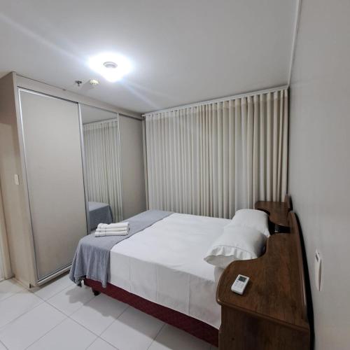una piccola camera da letto con un letto e una scrivania di Metropolitan Barcelona próximo ao Flamboyant e Autódromo Ar condicionado no quarto e na sala Piscina e jacuzzi no terraço academia completa restaurantes no térreo vaga privativa a Goiânia
