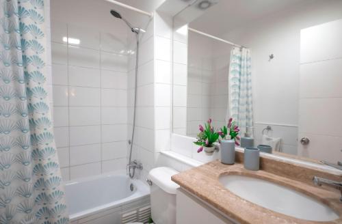 ein Badezimmer mit Waschbecken, Badewanne und Toilette in der Unterkunft Oceanic relájate cerca de todo in La Serena