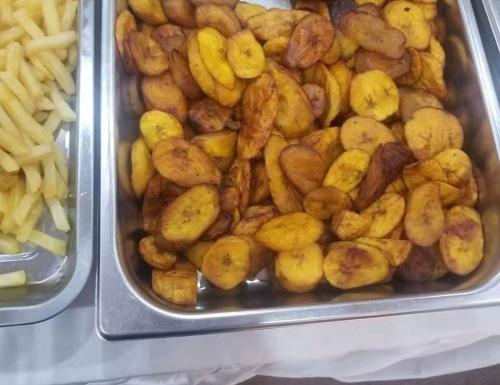 MatadiにあるBENJY palace hôtelのジャガイモとフライドポテトが載った食べ物のトレイ