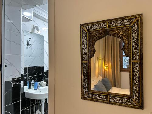 un baño con espejo y lavabo en Maison traditionnelle totalement privée au médina, en Chefchaouen