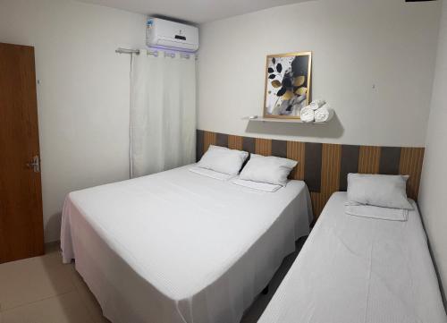 two beds in a small room with white sheets at Verão João Pessoa-apto inteiro-2 quartos in Cabedelo