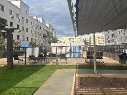 un patio avec des tables, des bancs et des bâtiments dans l'établissement Cozy 2-Bedroom Apartment 2 km from the Airport, à Várzea Grande