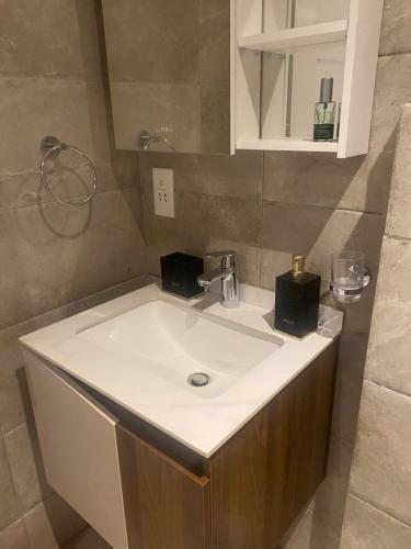 ein Badezimmer mit einem weißen Waschbecken und einem Spiegel in der Unterkunft Belrose Place in Accra