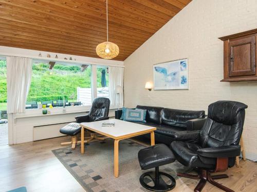 a living room with a couch and a table and chairs at 6 person holiday home in Aabenraa in Aabenraa