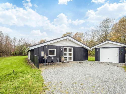 a black house with a white garage at 6 person holiday home in Oksbøl-By Traum in Oksbøl