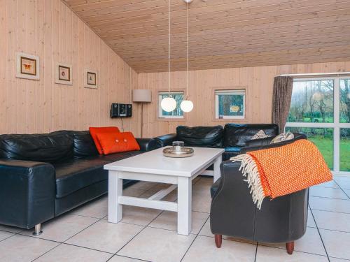 a living room with a black leather couch and a table at 6 person holiday home in Oksbøl-By Traum in Oksbøl