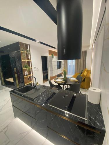 une cuisine avec un évier et un salon dans l'établissement Arad Apartamente Premium, à Arad