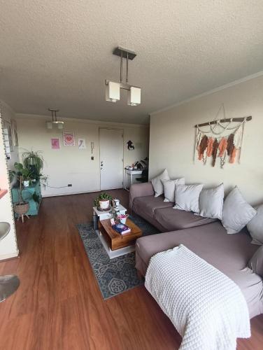 a living room with a couch and a table at Habitación privada en departamento compartido central in Chillán