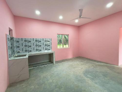 Ein leerer Raum mit rosa Wänden und einem Kamin in der Unterkunft rumah pt sari 