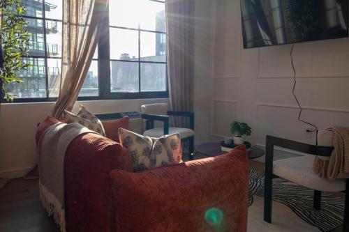 a living room with a couch and a chair at Lux Bronx Apt Rooftop, Pool, Gym, Cinema in Mott Haven