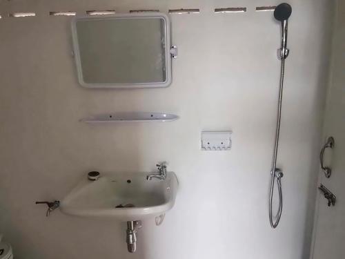 une salle de bain avec un lavabo et un miroir dans l'établissement Homestay Nunga หนูหง่าโฮมสเตย์คุณครู, à Mae Hong Son