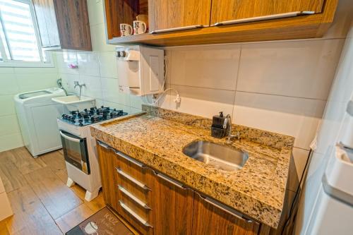 una cucina con lavello e fornello di Conforto e estilo inspirado em Nova York - Centro de Palmas a Palmas