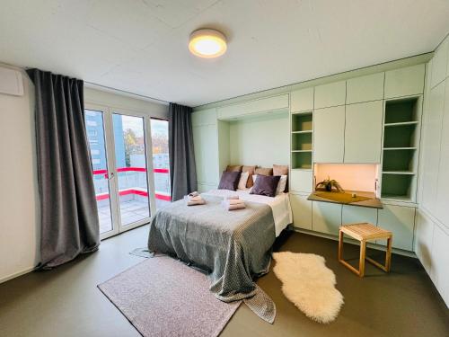 Un dormitorio con una cama y una ventana grande. en Modern Living, Luxe Studio Zurich, en Zúrich