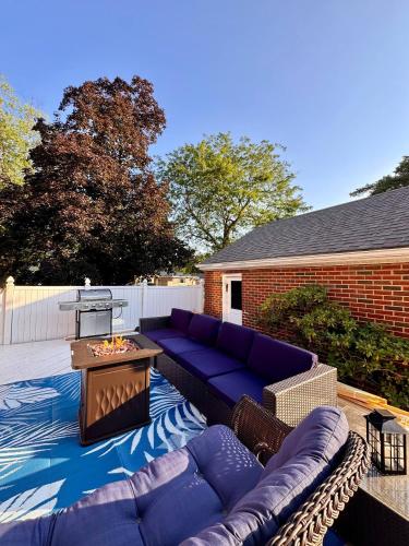 a patio with purple couches and a table at Profs Riverside Haven Art & Style Sleeps 10 in South Bend