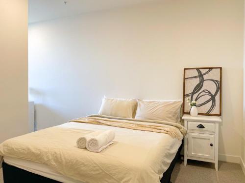 a bedroom with a bed with two towels on it at Mcity Morden 2BR with Free Parking in Clayton North