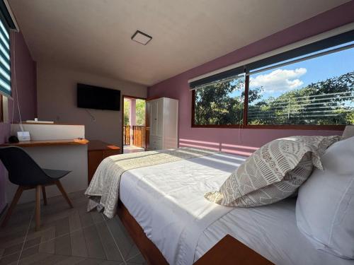 a bedroom with a bed and a large window at Casa en Huerto Frutal in Chicanna