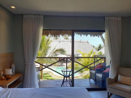 a bedroom with a bed and a view of a patio at Villas BobZ Barra grande in Barrinha