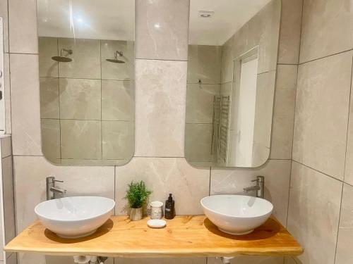 a bathroom with two sinks and a mirror at Voir la Mer - Grotto Bay in Grotto Bay