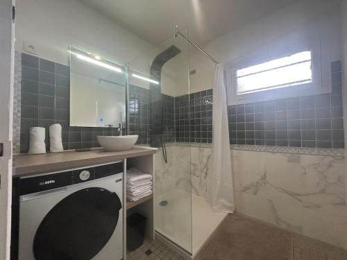 a bathroom with a sink and a shower at Maison chaleureuse à 2 minutes de la mer in Colleville-Montgomery