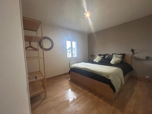 a bedroom with a bed and a book shelf at Maison chaleureuse à 2 minutes de la mer in Colleville-Montgomery