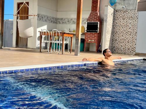 ein Mann in einem Swimmingpool in einem Haus in der Unterkunft Casa Trindade - Residencial Caminho da Praia in Porto Seguro
