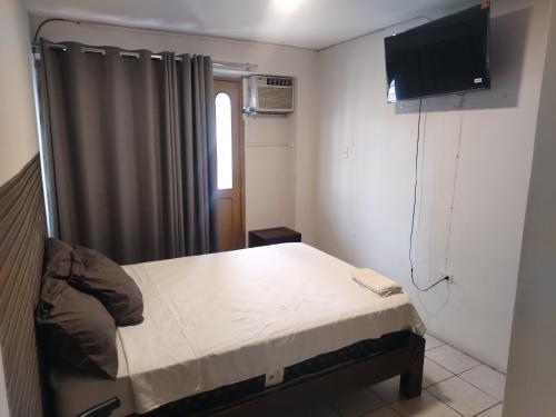 a bedroom with a bed and a flat screen tv at Hotel Casa Luna in Iquitos
