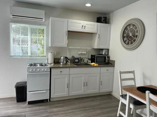 a kitchen with white cabinets and a stove top oven at Ventura Blvd Guest House in Litton Industries Heliport
