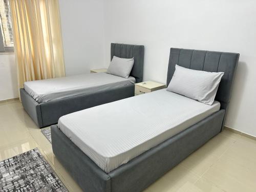 twee bedden naast elkaar in een kamer bij Premium Apartments Tirana Cumani in Tirane