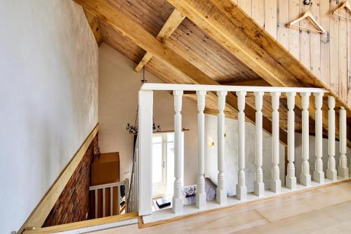 an attic staircase with white railings and a window at Lokven Hoeve in Vinkel