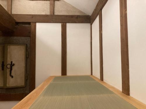 a room with wooden beams and a door at STAY local 石蔵 in Numazu