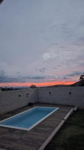 ein Swimmingpool auf dem Dach eines Gebäudes mit Sonnenuntergang in der Unterkunft Casa Container Jacu in Lavrinhas