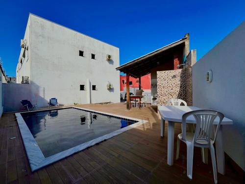 ein Haus mit einem Pool, einem Tisch und Stühlen in der Unterkunft Casa Trindade - Residencial Caminho da Praia in Porto Seguro