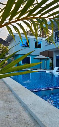 a building with a swimming pool in front of a building at Kosta Brava Hotel y Restobar in El Majahual