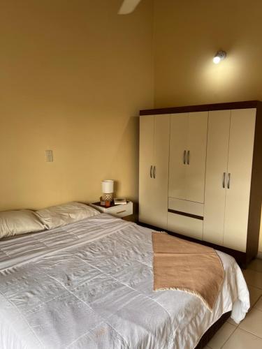 a bedroom with a large bed with white cabinets at Departamento in Fernando de la Mora