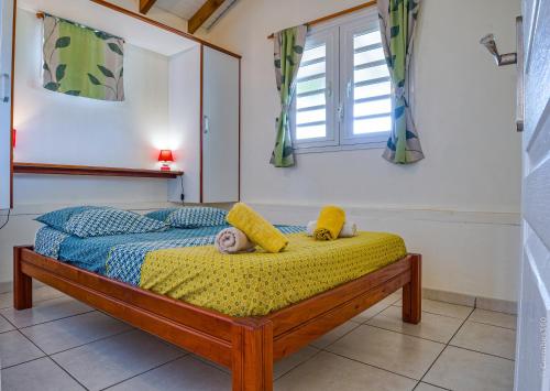 Ένα ή περισσότερα κρεβάτια σε δωμάτιο στο La Casita Verte vue sur mer & jardin tropical