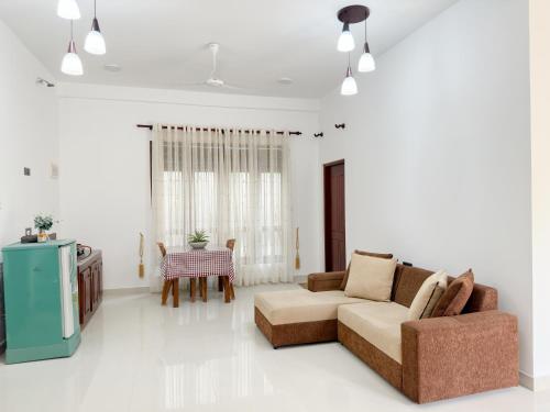 a living room with a couch and a tv at Villa Yoniky - Weligama in Weligama